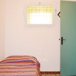 Habitación 3 con dos camas, mesitas, armario y espejo. Pared pintada de color lila.