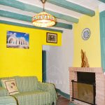 Salón con dos sofás, armario, chimenea y estantería