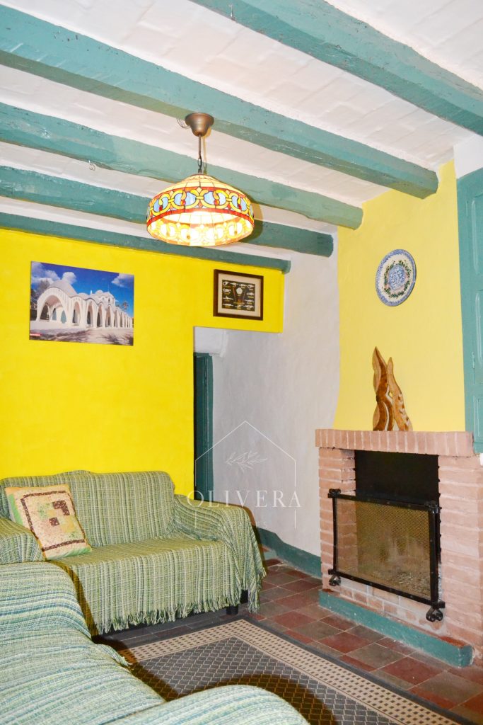 Salón con dos sofás, armario, chimenea y estantería