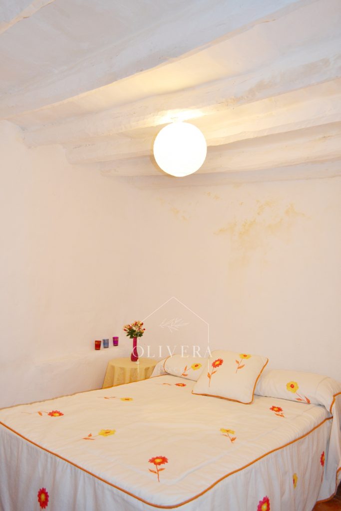 Habitación 2 con cama de matrimonio, mesitas, espejo y armario de tres puertas.