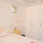 Habitación 2 con cama de matrimonio, mesitas, espejo y armario de tres puertas.