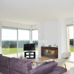 El salón-comedor es muy amplio, con una chimenea como protagonista y preciosas vistas al gran jardín (con césped natural) y al mar.