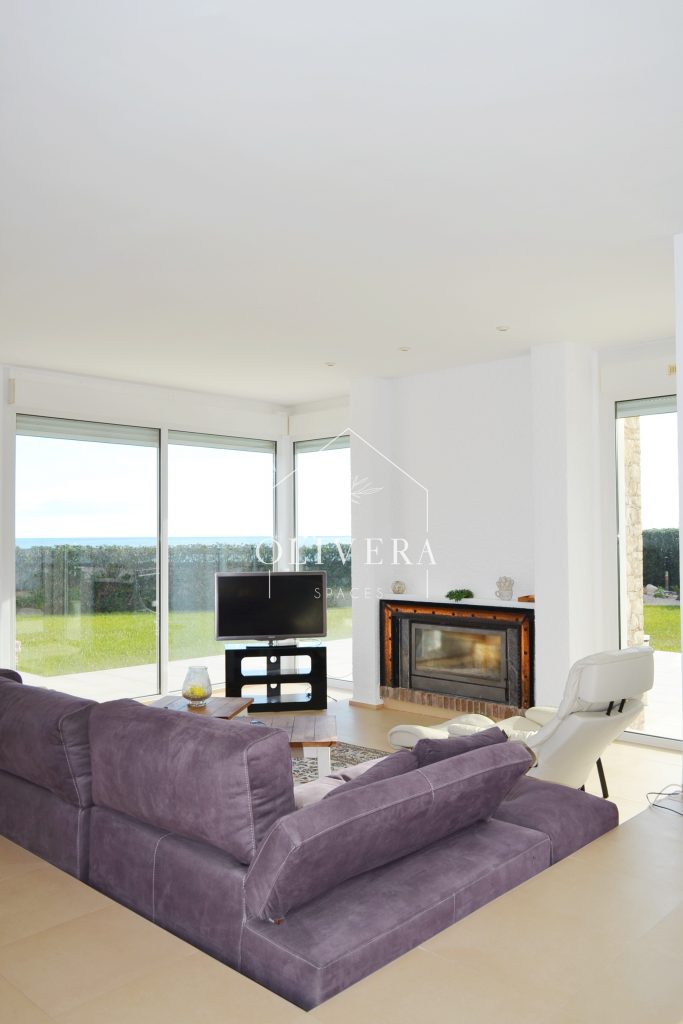 El salón-comedor es muy amplio, con una chimenea como protagonista y preciosas vistas al gran jardín (con césped natural) y al mar.