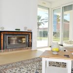 El salón-comedor es muy amplio, con una chimenea como protagonista y preciosas vistas al gran jardín (con césped natural) y al mar.