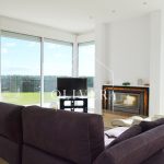 El salón-comedor es muy amplio, con una chimenea como protagonista y preciosas vistas al gran jardín (con césped natural) y al mar.