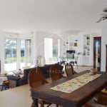 El salón-comedor es muy amplio, con una chimenea como protagonista y preciosas vistas al gran jardín (con césped natural) y al mar.