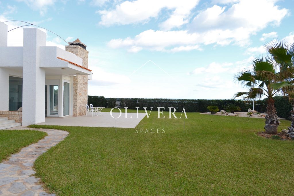exterior de la casa con jardín de césped natural y vistas al mar